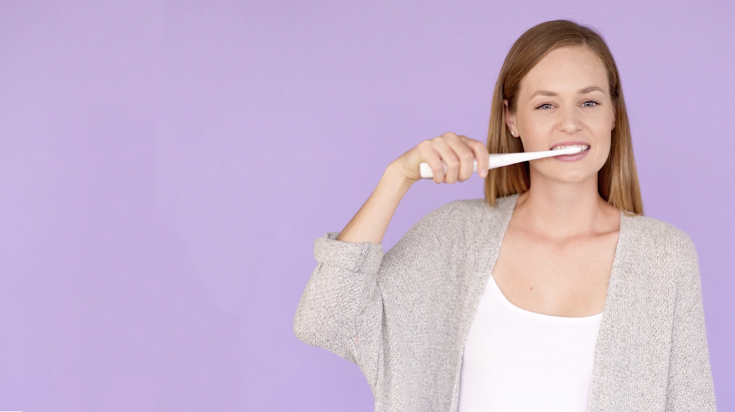 Young woman using Bristle electric toothbrush, Bristl, electric toothbrush, light therapy, phototherapy, sonic toothbrush, gingivitis, gum disease, dentist, teeth whitening, powered toothbrush